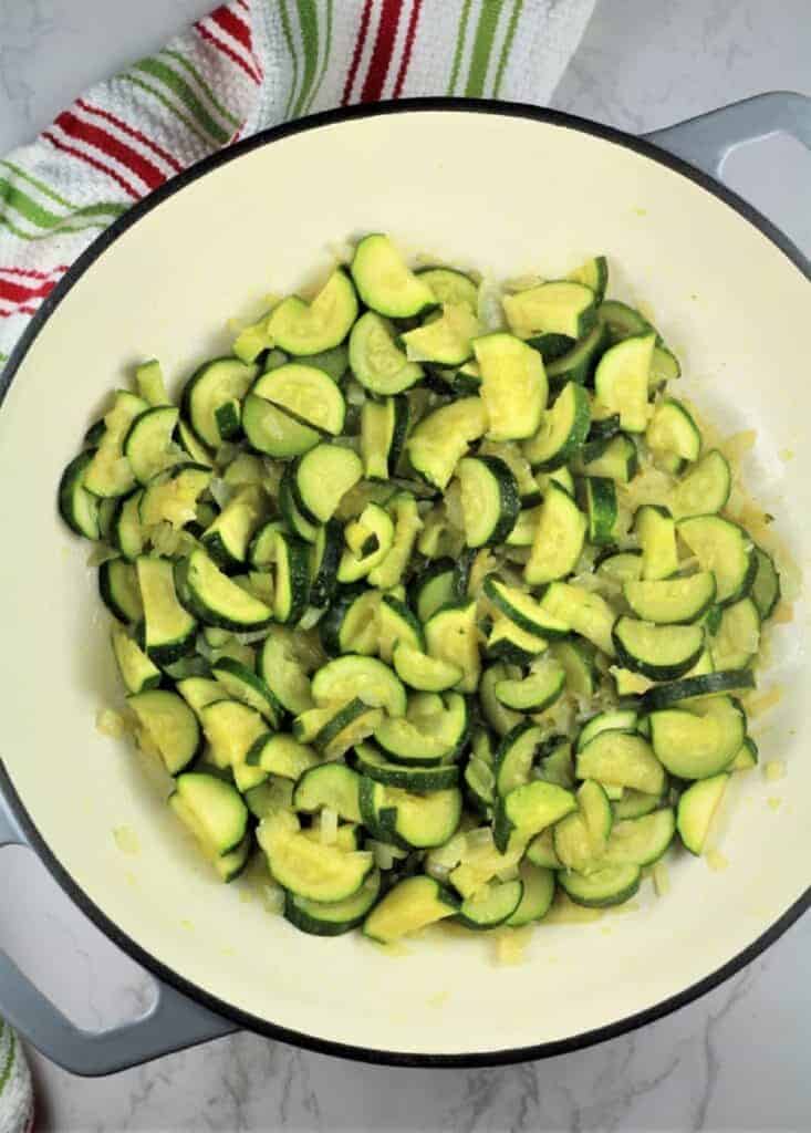 Sautéed zucchini and onion in skillet for pasta recipe.