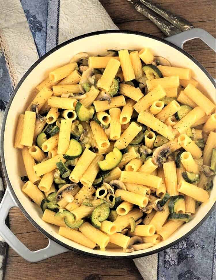 Skillet with pasta with zucchini and mushrooms.