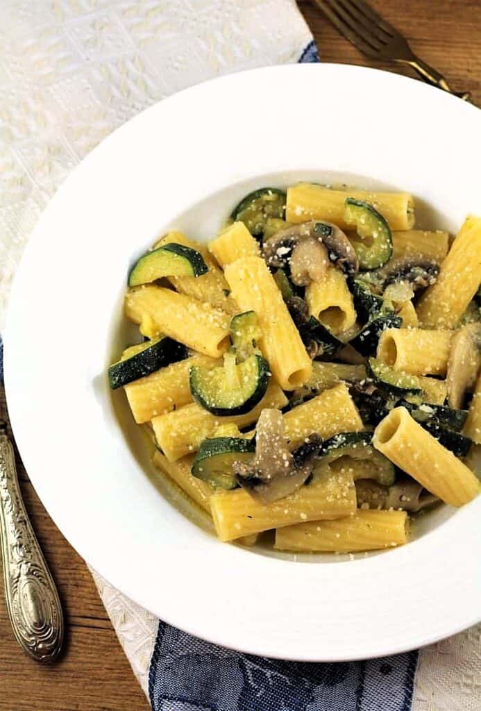 Bowl filled with pasta with zucchini and mushrooms.