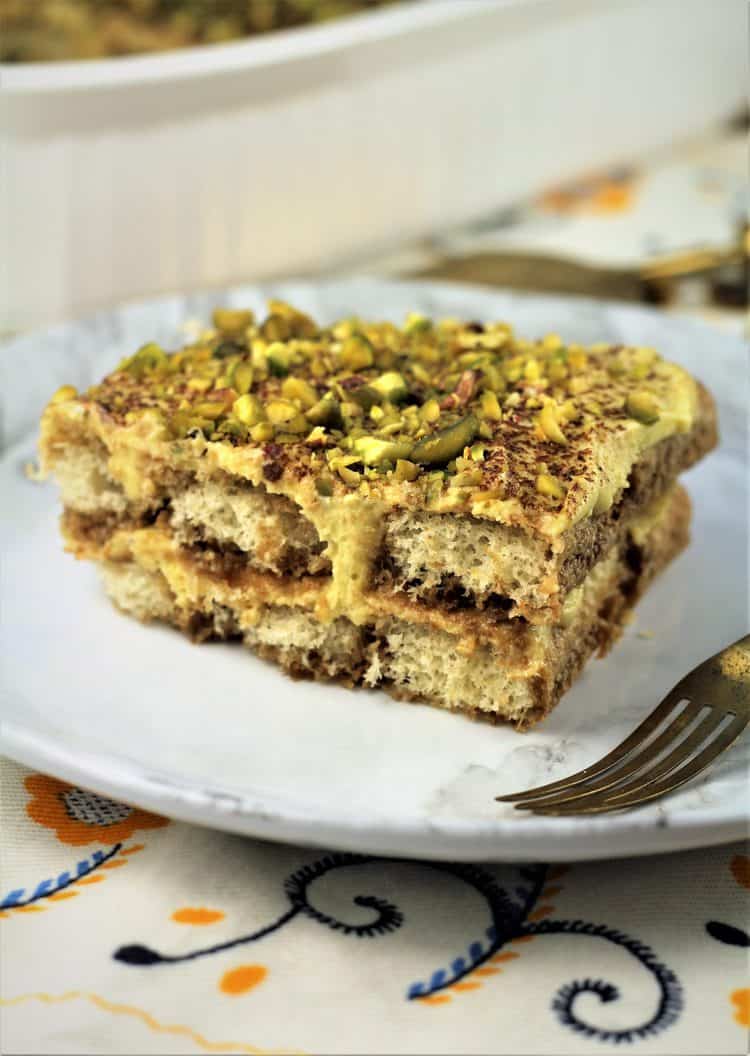 piece of pistachio tiramisu on white plate with fork