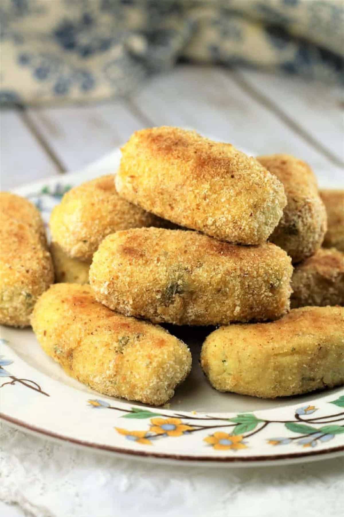 Baked mashed potato croquettes piled on plate.