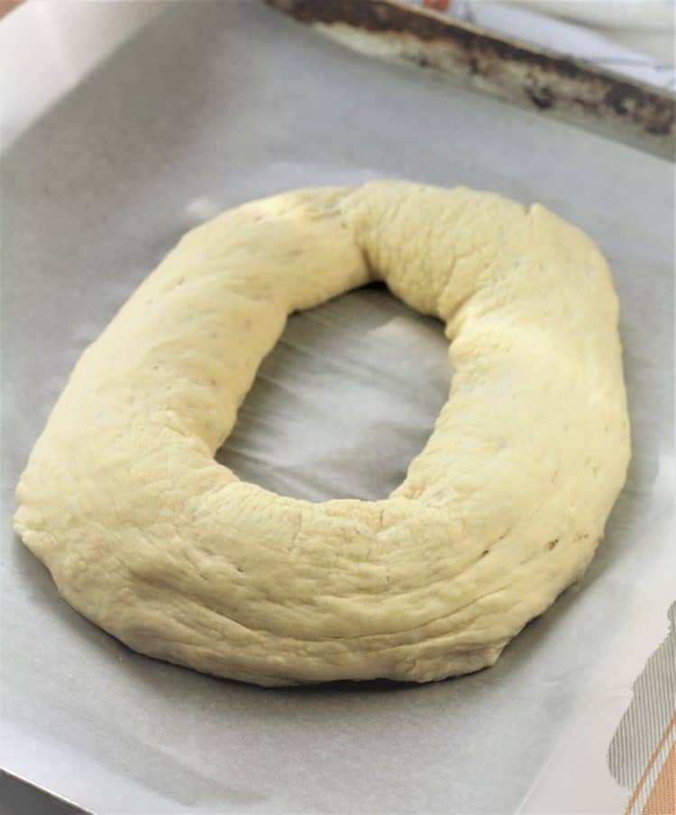 bread dough shaped as doughnut on baking sheet 