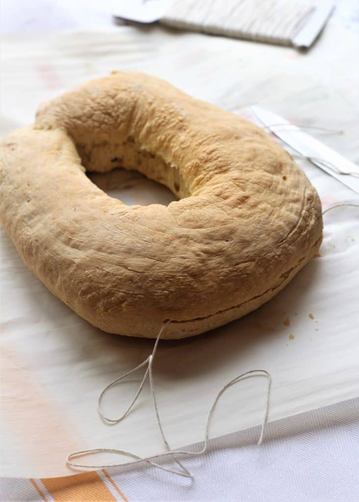 baked dough being cut in half with string
