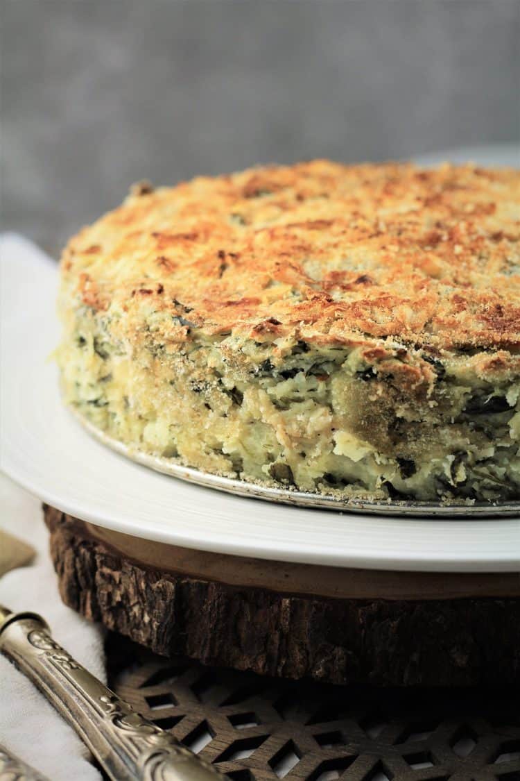 baked potato and spinach gateau with crisp breadcrumb coating on white plate