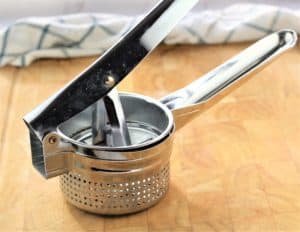 potato ricer on cutting board