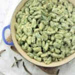 spinach gnocchi with butter sage sauce in blue skillet