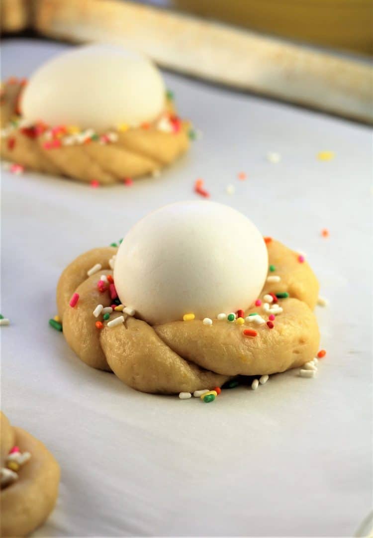 raw Easter cookie with egg in center on baking sheet
