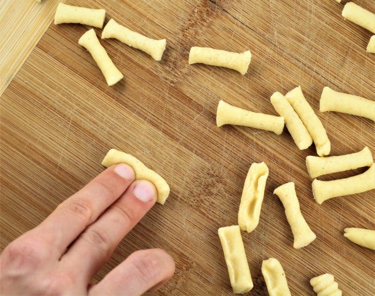 rolling cavatelli with fingers on a wooden board