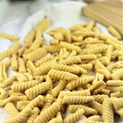 homemade cavatelli piled with gnocchi board behind them