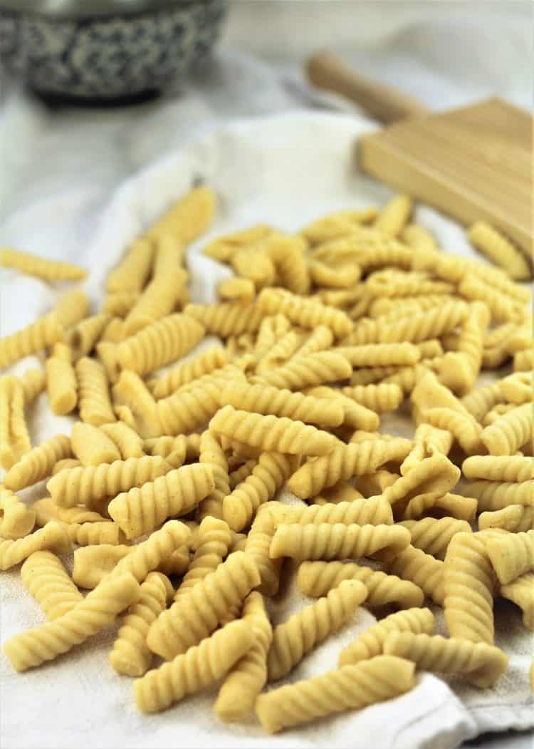 homemade cavatelli piled with gnocchi board behind them