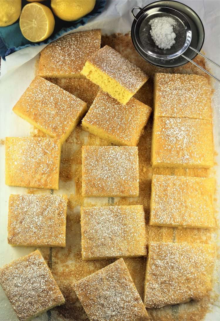 overhead view of squares of lemon-vanilla snack cake with powdered sugar