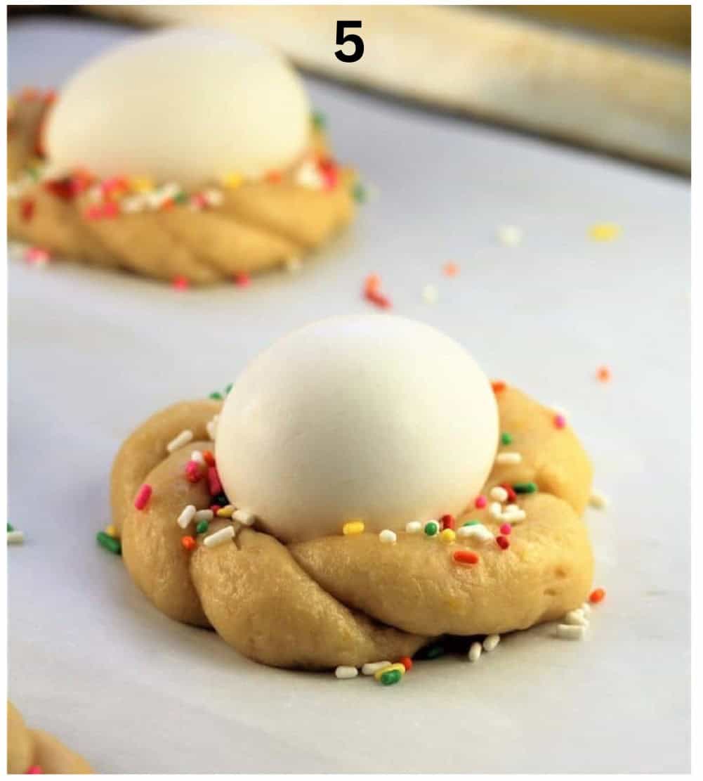 Sicilian Easter cookies with eggs in center on baking sheet.