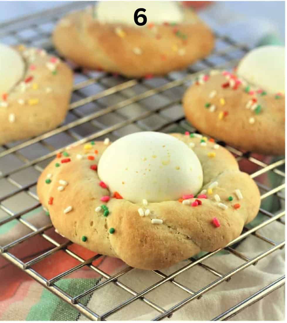 Just baked Sicilian Easter cookies with eggs on wire rack.