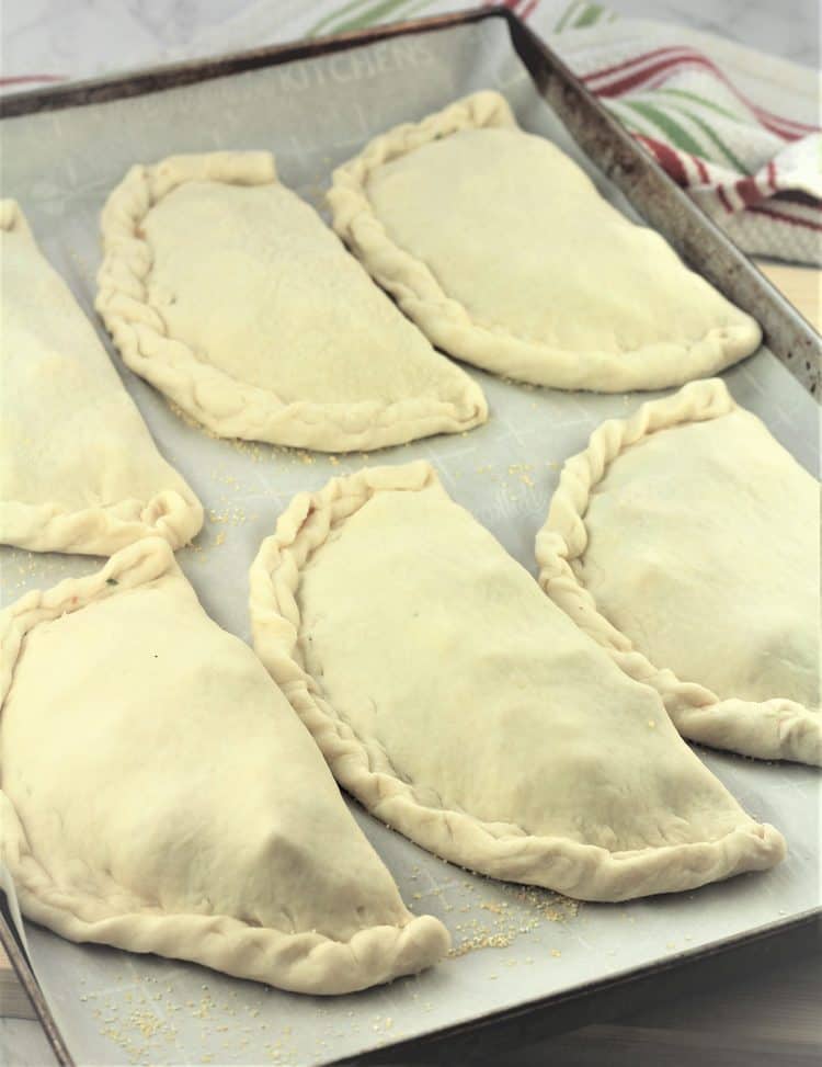 baking sheet filled with calzone to be baked