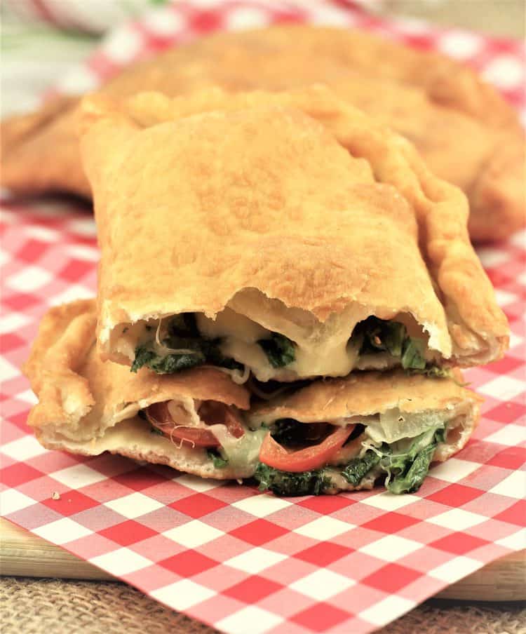 pitoni Messinesi (Sicilian Fried Calzone) cut in half to reveal escarole, tomato and cheese filling