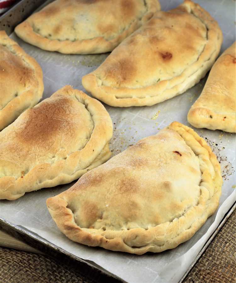 baking sheet filled with just baked calzone 