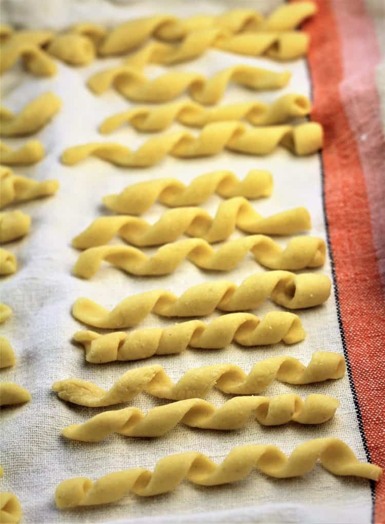 tray of fresh busiate pasta on dish cloth