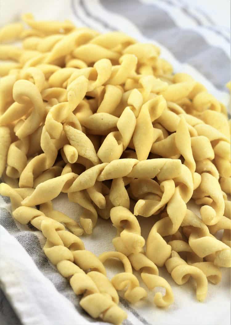 pile of homemade busiate pasta on dish cloth 