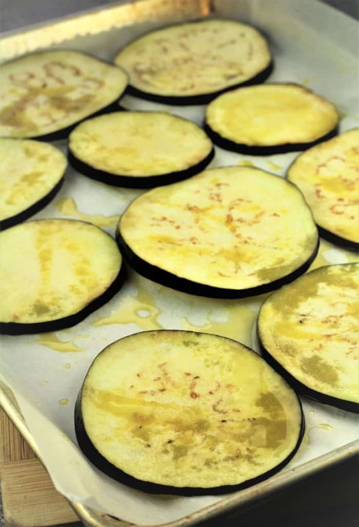 roasted eggplant slices on baking sheet drizzled in olive oil