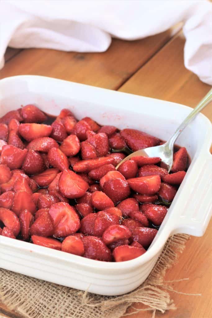 balsamic strawberries in white square plate with spoon in it