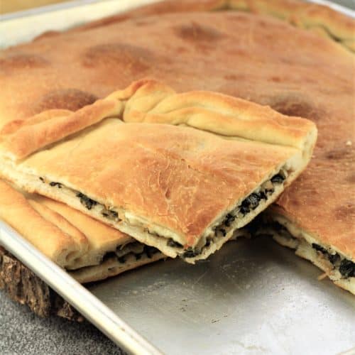 square of swiss chard pizza on baking sheet