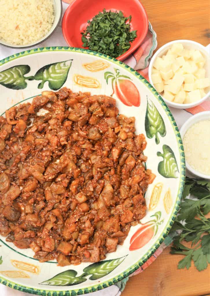 cooked eggplant flesh in large bowl with bowls of ingredients around it