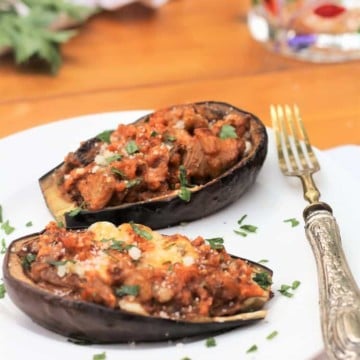 stuffed baby eggplant halves on white plate
