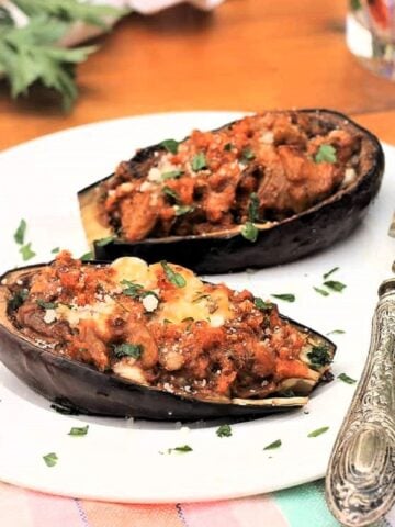 Stuffed baby eggplant halves on plate with fork.