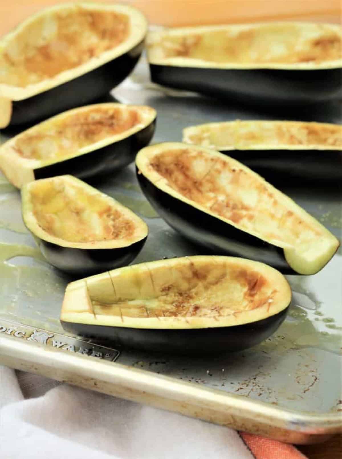 Hollowed eggplant halves on baking sheet.