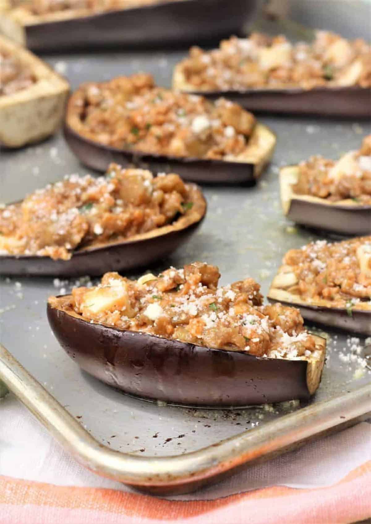 Stuffed baby eggplant halves on baking sheet.