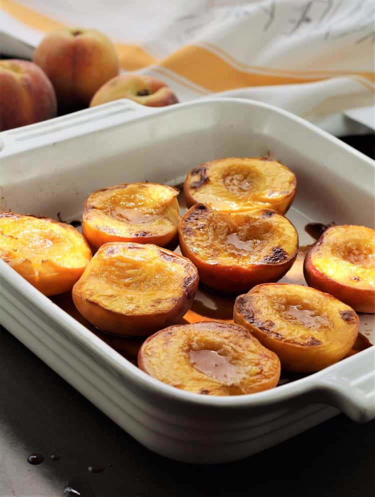 maple roasted peach halves in square baking dish