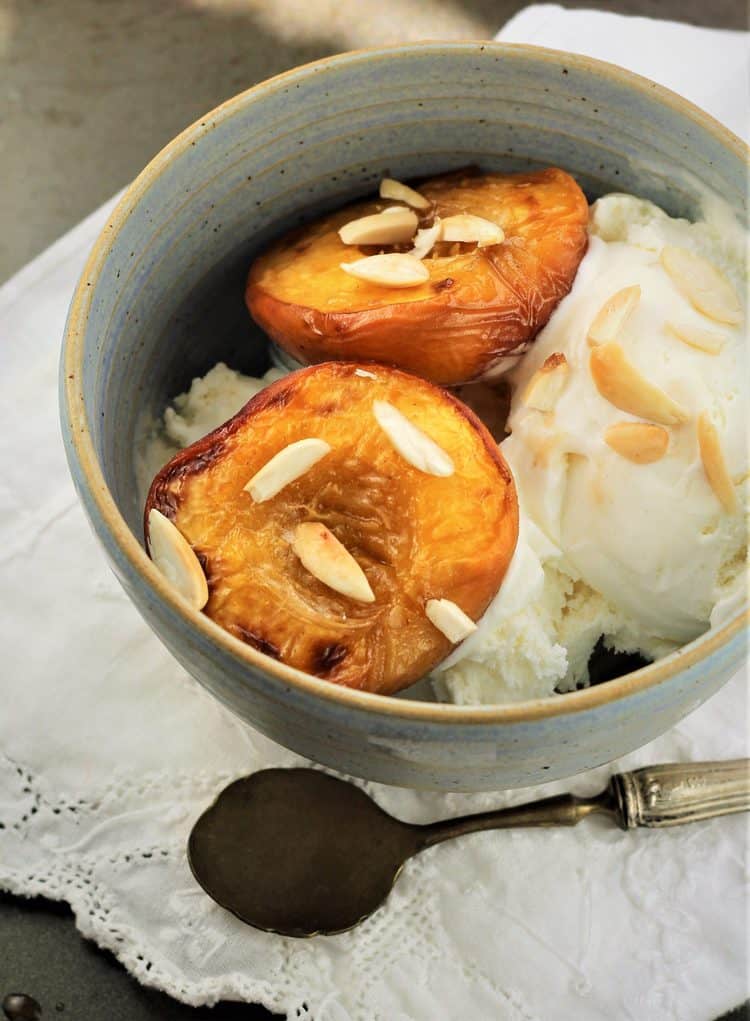 maple roasted peaches with ice cream in bowl with spoon