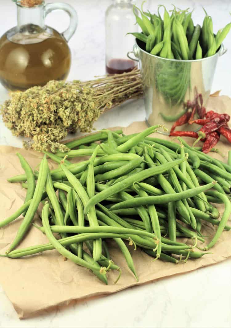 pile of green beans, dry oregano, dried chili, olive oil bottle