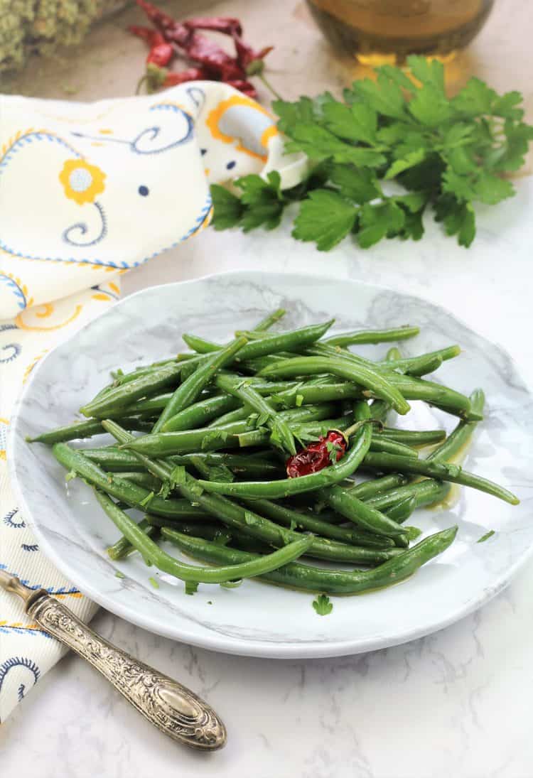 green bean salad in white plate with fork on side 