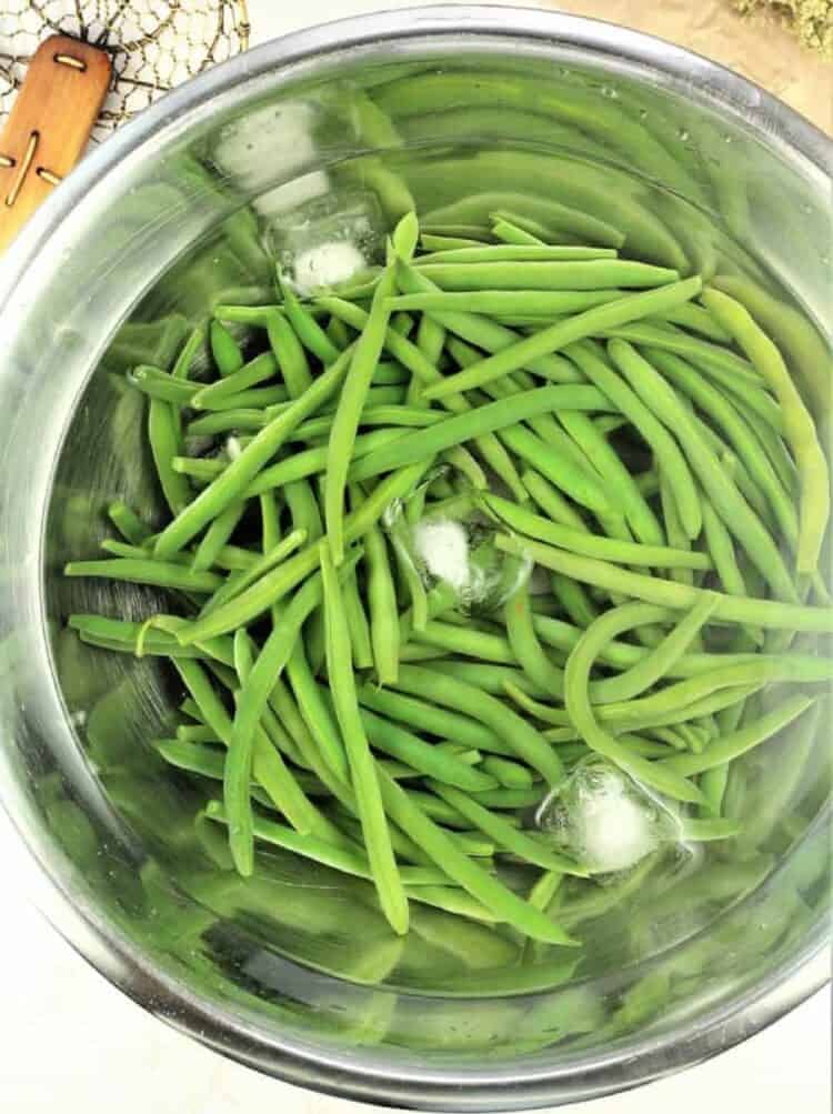 Boiled green beans plunged into ice bath.