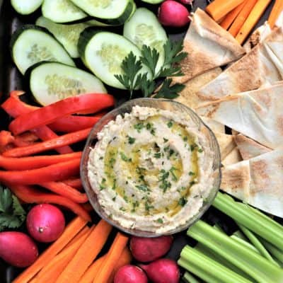bowl of white bean dip surrounded by crudités