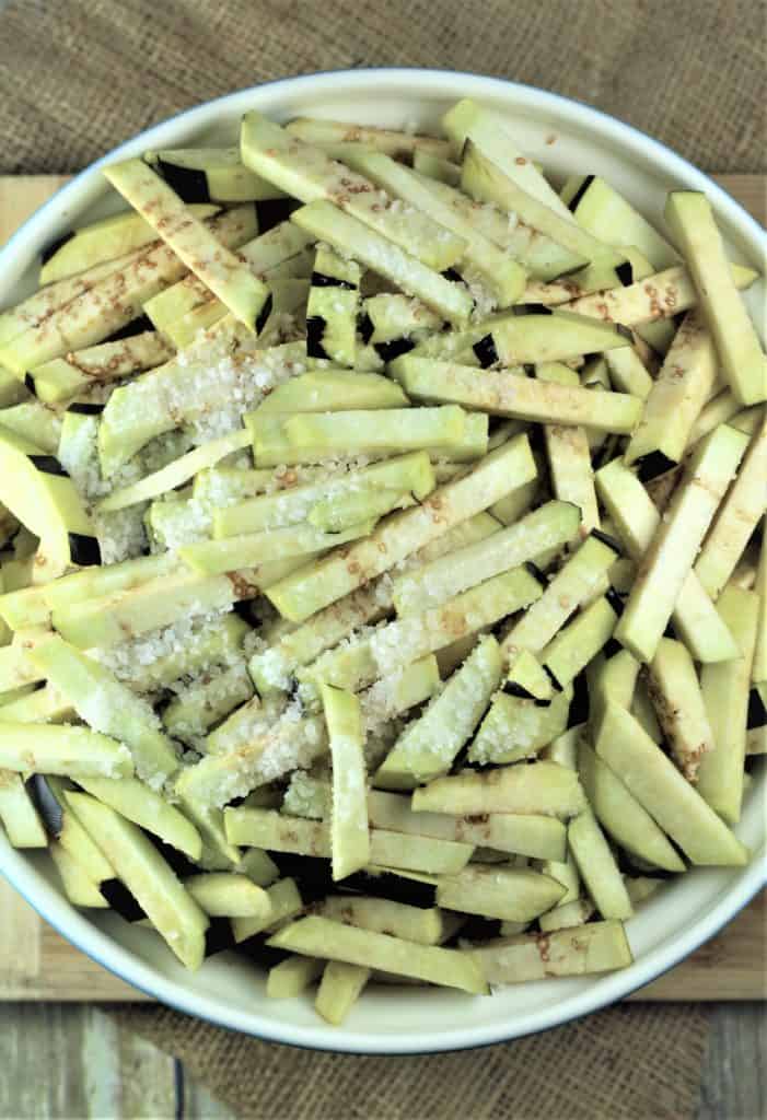 salted eggplant strips in large bowl