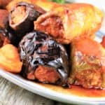 stuffed peppers and eggplant with tomato sauce piled on a platter