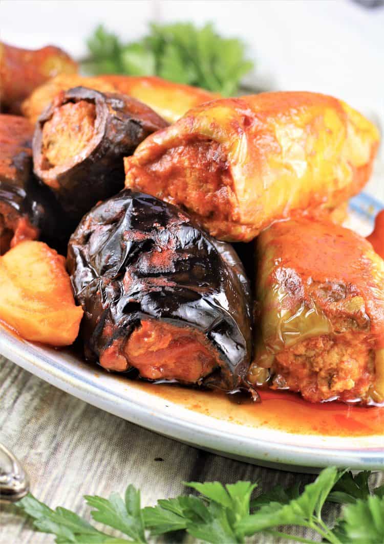 stuffed eggplant and peppers in tomato sauce piled onto a serving plate