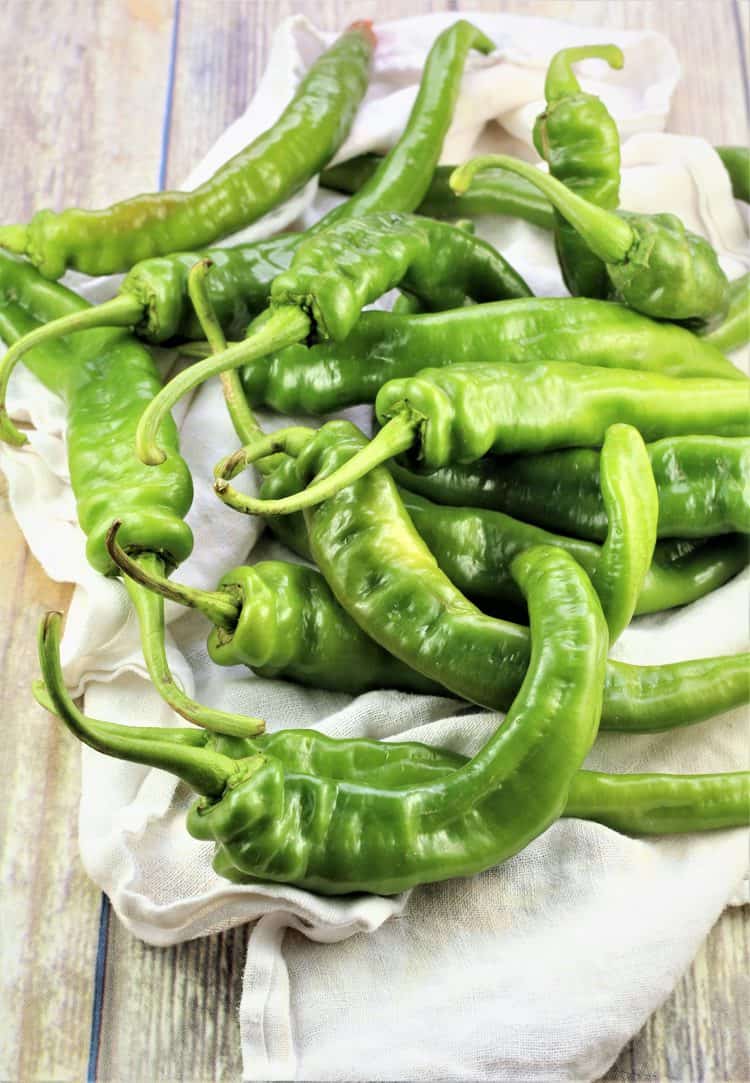 pile of green hot peppers on dish cloth