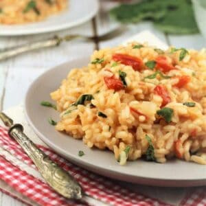 Tomato and basil risotto plated next to fork.
