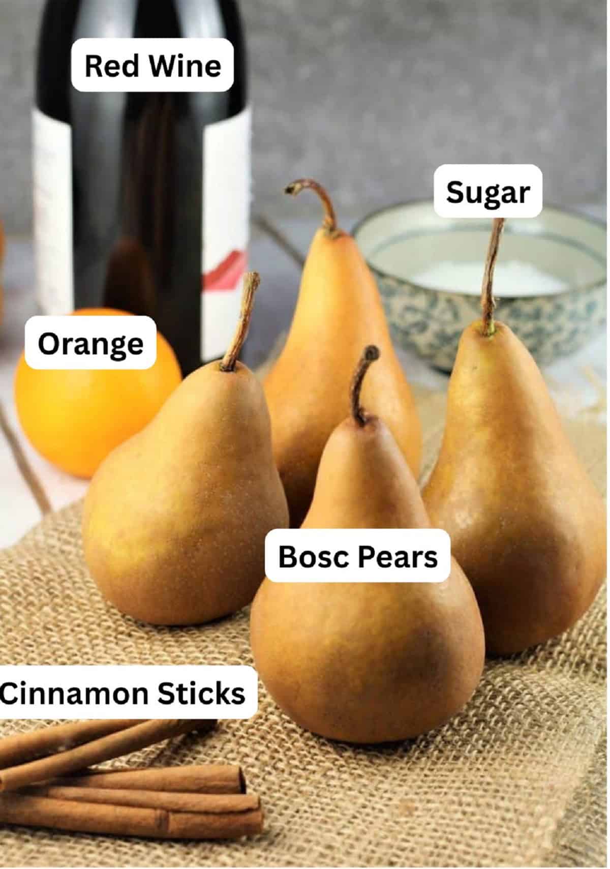Bosc pears, sugar, orange, cinnamon sticks and red wine for poached pears recipe.