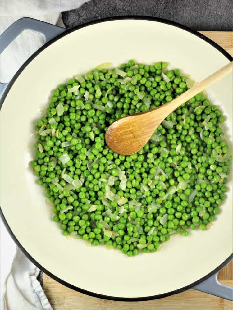 large skillet with peas and onion