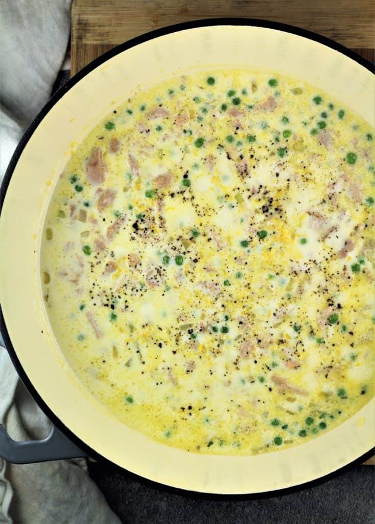 large skillet with cream sauce with peas and tuna 