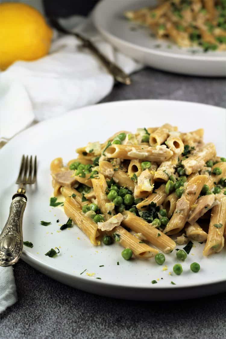 white round plate with Pasta with Tuna and Peas in a Cream Sauce and fork on side