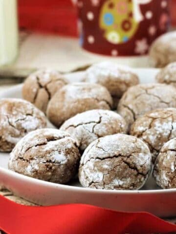 Amaretti cookies with cocoa powder on plate.