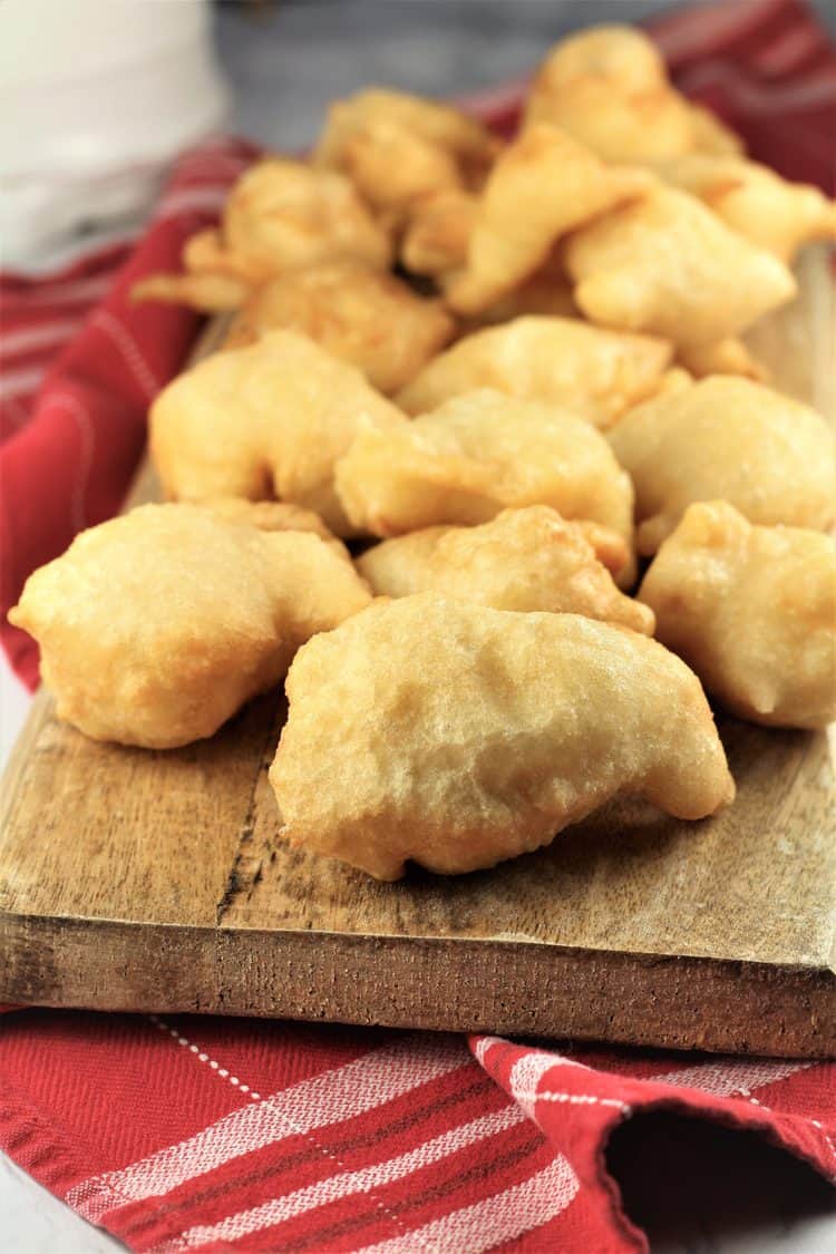 Sfinci (Sicilian Fried Dough) on wood board and red cloth underneath