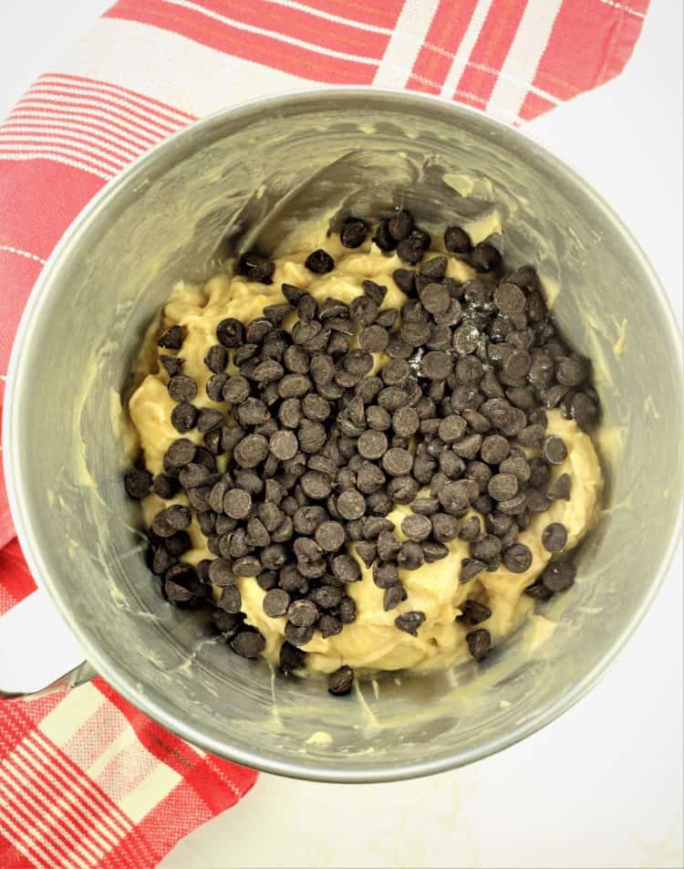 chocolate chips sprinkled over dough in stand mixer bowl