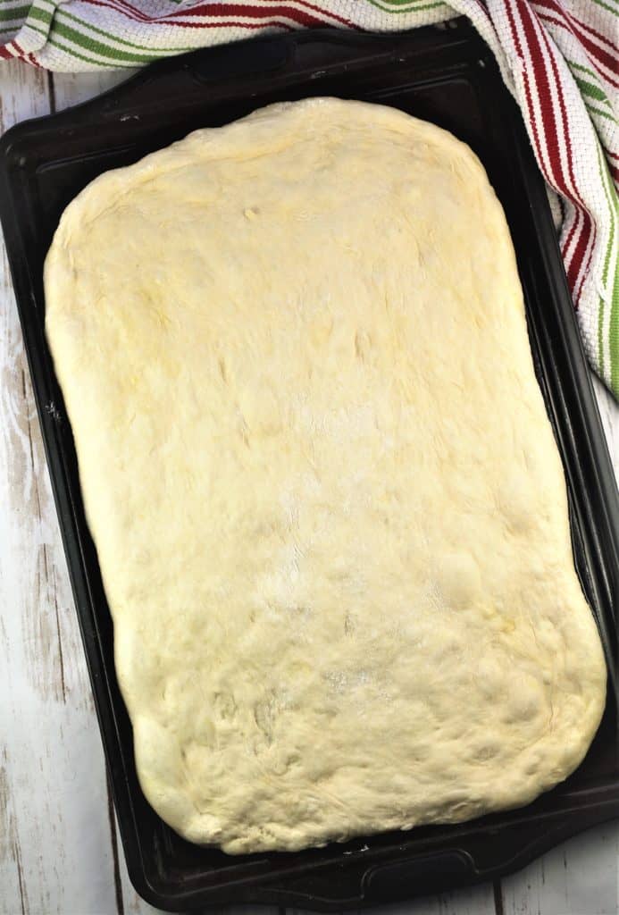 no knead pizza dough placed on baking sheet 