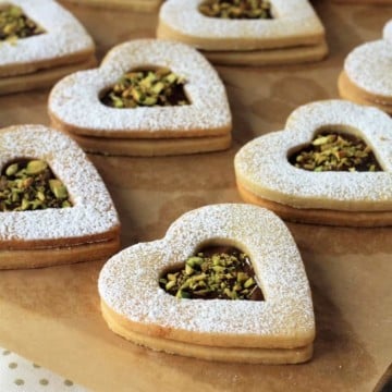Nutella and pistachio heart cookies on wood board